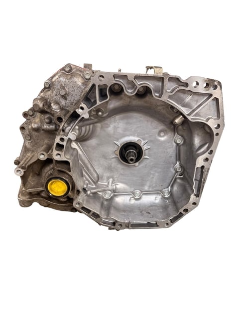 Metal automotive transmission or engine housing component with yellow drain plug and central shaft, isolated on white background