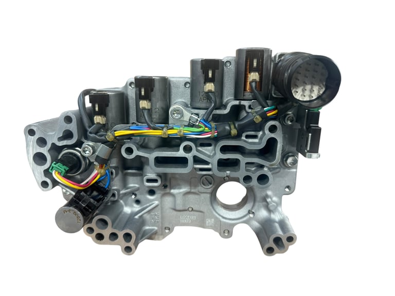Transmission valve body assembly showing solenoids, connectors, and internal passages on white background